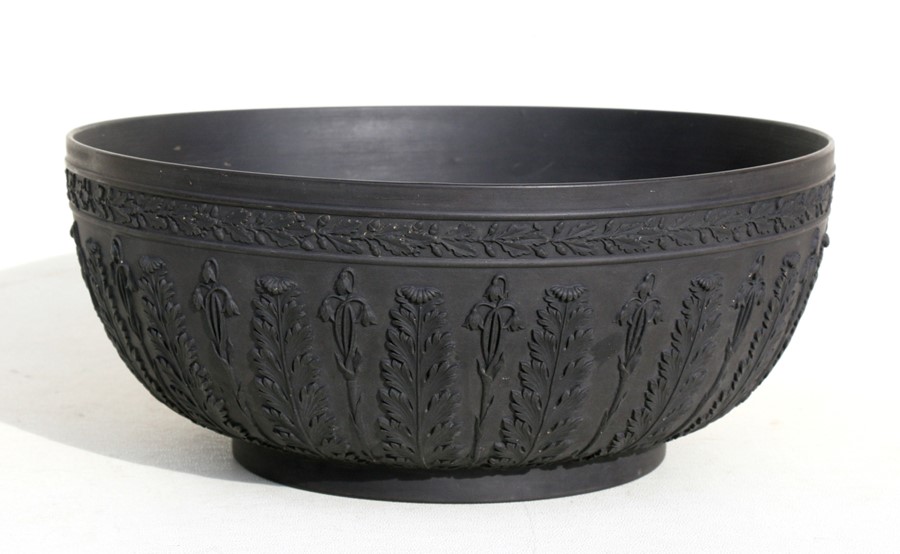 A Wedgwood black basalt bowl decorated with flowers and foliage, 28cms (11ins) diameter (restored).