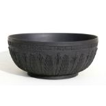 A Wedgwood black basalt bowl decorated with flowers and foliage, 28cms (11ins) diameter (restored).