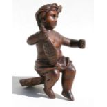 A continental carved wooden model of a putto holding a flask, 17cms (6.75ins) high.