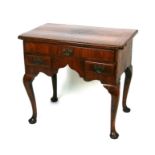 A George II walnut lowboy with rectangular quarter veneered crossbanded top above one long and two