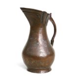 An Islamic tinned copper ewer decorated with foliate scrolls with signature to the handle, 33cms (