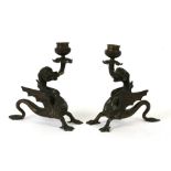 A pair of bronze stylised dragon candlesticks, 20cms (8ins) high.