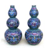 A pair of Chinese porcelain triple gourd vases decorated with flowers on a blue ground, blue seal