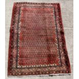 A Persian Arak woollen hand knotted rug with repeated design a beige ground, 190 by 130cms (75 by