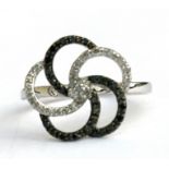 A 9ct white gold black and white diamond cluster ring, approx UK size 'N'.