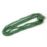 A Chinese Bowenite three-strand bead necklace, 46cms (18ins) long.