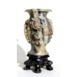 A Chinese figured grey soapstone vase carved with flowers on a pierced stand, 26cms (10ins) high.