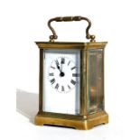A brass carriage time piece, the white enamel dial with Roman numerals, 11cms (4.25ins) high.