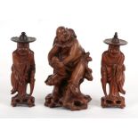 A Chinese hardwood figure of a man on a rocky outcrop. 17cm ( 6.25 ins) high, together with a pair