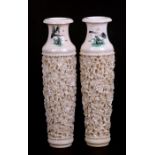 A pair of early 20th century Chinese ivory vases, deeply carved with flowering foliage, 20cms (8ins)