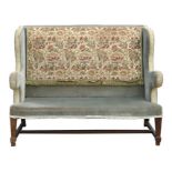 An upholstered wing back two-seater sofa on square tapering legs, 132cms (52ins) wide.Condition