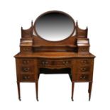 An Edwardian figured mahogany dressing chest, the oval mirror flanked by two jewellery drawers,