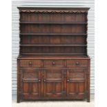 A carved oak dresser with three frieze drawers and cupboards beneath, 163cms (60ins) wide.