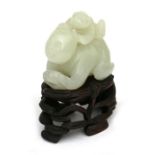 A Chinese jade carving in the form of a crawling figure with a child on their back, on a pierced