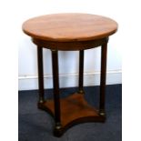 A circular Biedermeier-style mahogany centre table on turned columns with gilt-metal capitals united