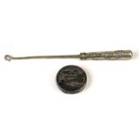 A Chinese white metal button hook with dragon decorated handle, 23cms (9ins) long; together with a