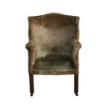 An upholstered barrel backed armchair on square tapering legs.