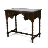 A carved oak writing table with two short drawers flanking a kneehole, on turned legs joined by a