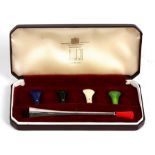 A cased Dunhill silver cigarette holder with five interchangeable mouth pieces in blue, black,