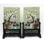 A pair of Chinese jade and hardstone table screens on hardwood stands, 20 by 27cms (8 by 10.5ins).