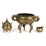 A Chinese polished bronze two-handled tripod censer decorated with prunus and impressed seal mark to