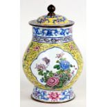 A Chinese enamel lidded vase decorated with butterflies and flowers on a yellow ground, 21.5cms (8.