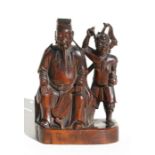 An 18th century Chinese carved hardwood group depicting a seated official and a demon, 16cms (6.
