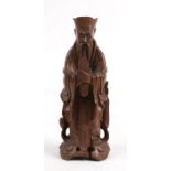 A Chinese carved hardwood figure in the form of a robed scholar, 20cms (8ins)