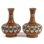 A pair of Doulton Silicon vases decorated with flowers, 11cms (4.25ins) high.
