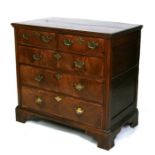 An 18th century oak and walnut chest with two short and three long graduated drawers, on bracket