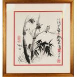 A Chinese picture depicting a bird amongst bamboo and calligraphy, framed and glazed. 34 by 38cm (