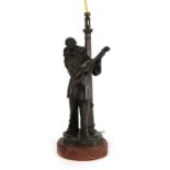 A bronzed spelter table lamp in the form of a Pierrot standing in front of a lamp post, 37cms (14.