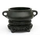 A Chinese bronze two-handled censer with six character mark to underside, on a hardwood stand, 13cms