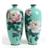 A pair of Japanese Meiji period cloisonne vases decorated with flowers on a pale green ground, 18cms