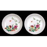 A pair of Chinese famille rose saucer dishes decorated with flowers, 15cms (6ins) diameter.