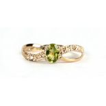A 9ct gold peridot ring with diamond set shoulders, approx UK size 'O'.