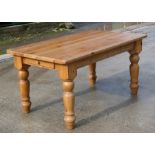A modern pine rectangular kitchen table on turned legs, 152cms (60ins) long.