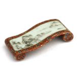 A Chinese porcelain brush rest in the form of a scroll, decorated with a landscape scene, 8cms (3.