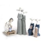 A Lladro group depicting two nuns, 33cms (13ins) high; together with two similar smaller and another