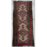A Caucasian woollen hand knotted runner with geometric design within floral borders on a beige