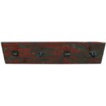 A set of coat hooks on a painted backboard, 115cms (45.25ins) wide.