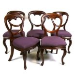Five Victorian mahogany balloon back dining chairs with upholstered seats, on cabriole front