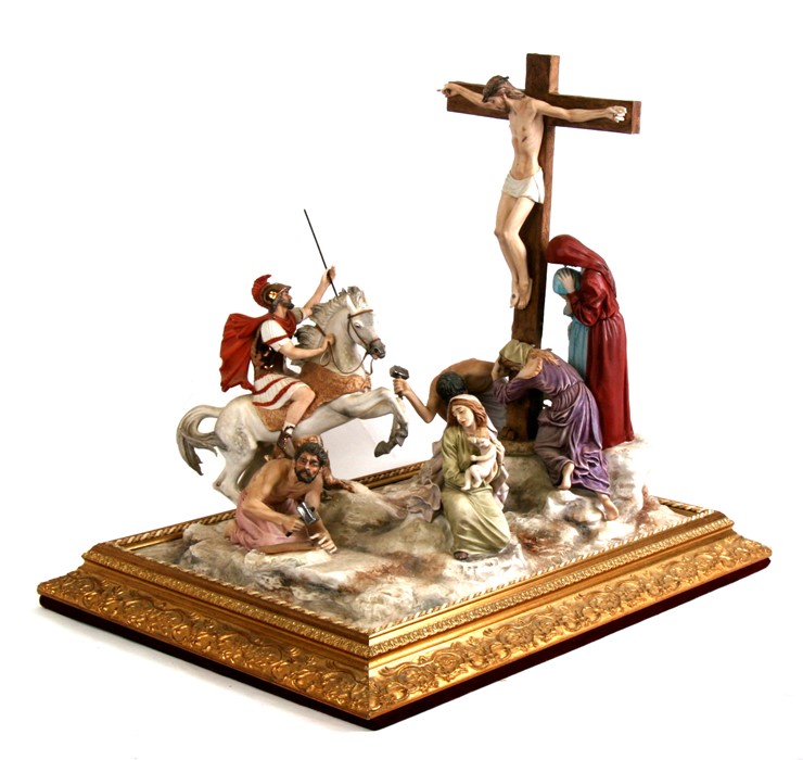 A large Capodimonte porcelain figural group depict Christ's Crucifixion, mounted on a gilded