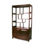 A Chinese hardwood display stand with multi level shelves above a pair of carved cupboard doors,