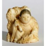 A 19th century Japanese carved ivory netsuke in the form of a boy holding a calligraphy brush, 3.