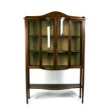 A late 19th / early 20th century bow fronted glazed display cabinet, 107cms (42ins) wide.