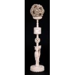 A late 19th / early 20th century Chinese ivory puzzle ball on figural stand, 38cms (15ins) high, the