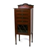 An Edwardian inlaid mahogany music cabinet with four drawers with drop down fronts above a glazed