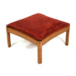 An Ercol honey oak footstool, 59cms (23.25ins) wide.