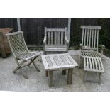 A group of well weathered teak garden furniture to include a steamer chair and table (4).
